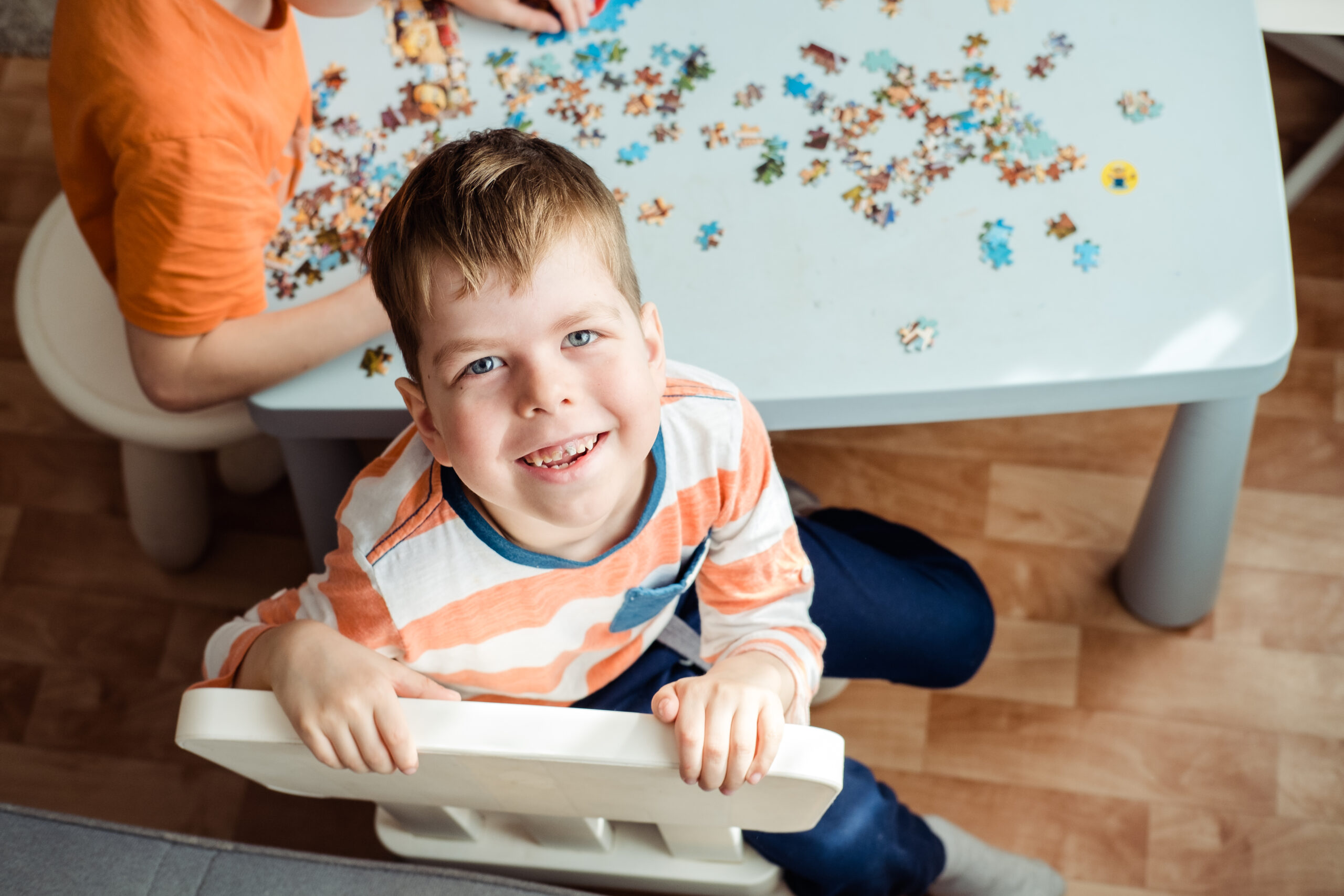 a boy of 6 years old collects a puzzle at home and looks at the camera with a smile a boy of 6 years old collects a puzzle at home and looks at the camera with a smile